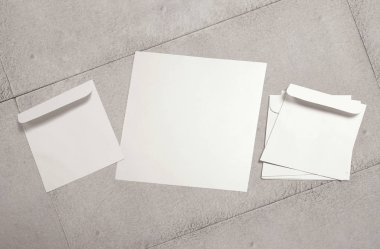 Beyaz zarf ve arka planda kartpostal. Üst görünüm boş zarf modeli ve boş antet sunum şablonu. Tasarımınız için boş sayfa.