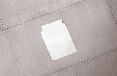 Beyaz zarf ve arka planda kartpostal. Üst görünüm boş zarf modeli ve boş antet sunum şablonu. Tasarımınız için boş sayfa.