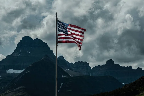 Old Glory, Amerikan Bayrağı, Montana Buzul Ulusal Parkı 'ndaki Swiftcurrent Gölü üzerinde fırtınalı bir gökyüzüne karşı duruyor.