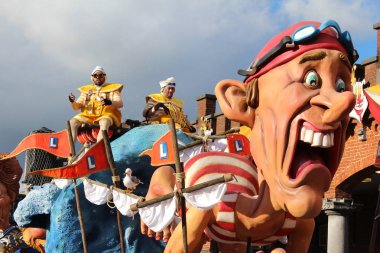 Aalst, Belçika, 12 Şubat 2018: Aalst 'taki yıllık karnaval geçit töreninde parlak renkli şamandıralardan biri ve katılımcılardan biri. Bu, soyut Kültür Mirasının Unesco tarafından tanınan bir olayıdır.. 