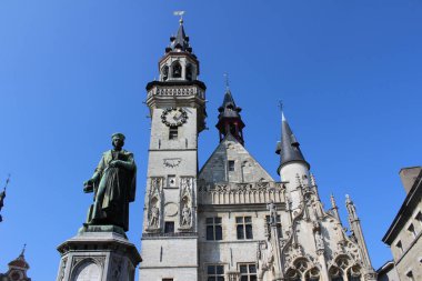 Aalst, Belçika, 17 Mart 2016: İkonik saat kulesi, Dirk Martens ve Alderman 'ın evinin ana pazar meydanında bulunan heykeli, Aalst. Aalst, Doğu Flanders 'da yıllık karnaval geçit töreniyle tanınan büyük bir kasaba..