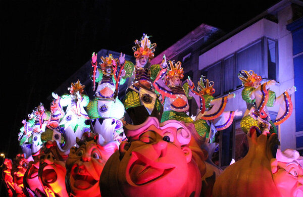 AALST, BELGIUM, FEBRUARY 26 2017: Unknown participants on one of the brightly lit floats during the annual carnival parade in Aalst, which is a UNESCO recognized event of Intangible Cultural Heritage.
