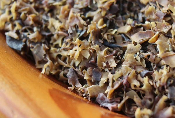 İrlanda yosunlarıyla (Chondrus crispus) dolu ahşap bir kâseye aşırı yakın çekim. Ev yapımı süreçte bira cezalarını hafifletmek için kullanılan yaygın bir kırmızı alg. Seçici odak.
