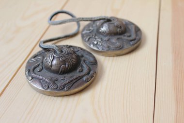 Tingsha (Ting-sha), Tibet meditasyon çanları yakın plan, doğal ahşap arka plan izole. Seçici odak, sağdaki telif alanı.