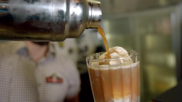 Barista nalévá z koktejlu kávu do šálku se zmrzlinou — Stock video