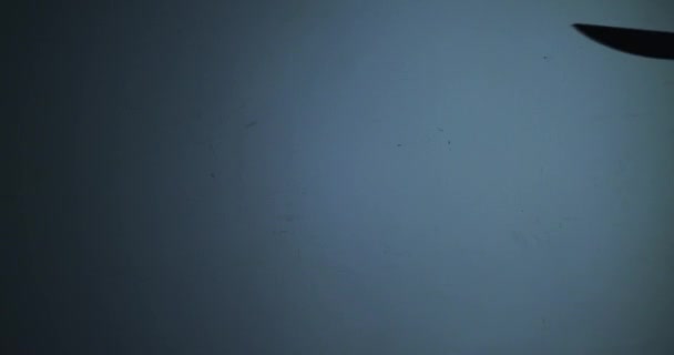 Die Form einer Hand mit einem Messer auf blauem Hintergrund, die bereit ist, jemanden zu töten — Stockvideo