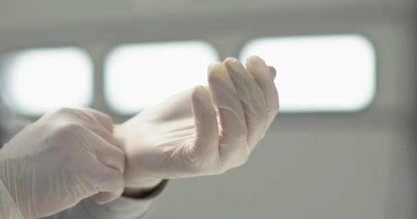 The young man puts on a white latex glove — Stock Video