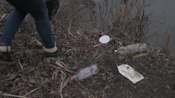 Eine Frau Sammelt Müll Und Legt Ihn Eine Schwarze Plastiktüte — Stockvideo