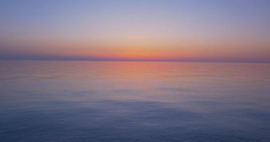 Gün batımından sonra, bulutsuz ufuk manzaralı sakin bir denizde akşam..