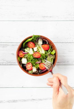 Kadın ellerinde sebze salatası tabağı. Üst görünüm