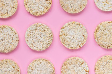 Pembe arka planda pirinç keki. Düz yerde, üst tarafta. Arkaplanda pirinç waffle 'ı.