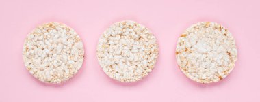 Pembe arka planda pirinç keki. Düz yerde, üst tarafta. Arkaplanda pirinç waffle 'ı.