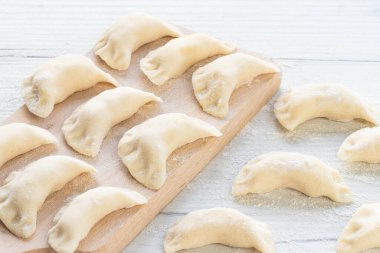 Hafif bir arka planda hamur tatlısı pişirmek. Tahtada patatesli hamur tatlısı.