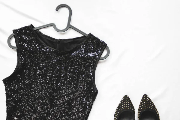 ハンガーにスパンコールと光の背景に靴を持つ女性の黒のドレス 最上階だ スタイリッシュなパーティーアクセサリー — ストック写真