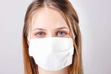 Yüzünde tıbbi maske olan kadın. Virüslere ve enfeksiyonlara karşı koruma. Evde kal, Corona virüsü..