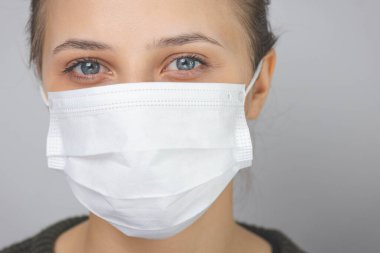 Yüzünde tıbbi maske olan kadın. Virüslere ve enfeksiyonlara karşı koruma. Evde kal, Corona virüsü..