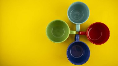 Sarı arka planda çok renkli kupalar.