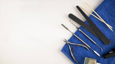 Manikür aletleri mavi havlunun üzerinde duruyor.