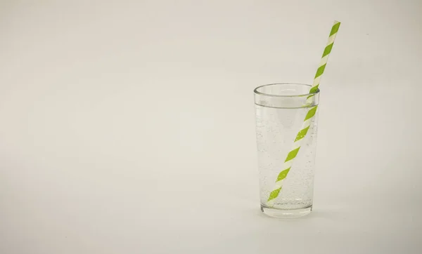 Een Glas Water Een Witte Achtergrond Met Een Cocktailtube — Stockfoto