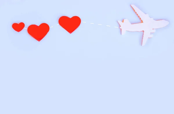 Avião de brinquedo na mesa azul com coração vermelho — Fotografia de Stock