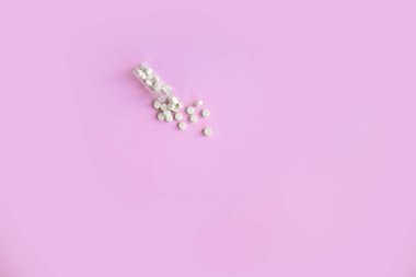 Pembe arka planda homeopatik globullar ve cam şişe. Alternatif Homeopati