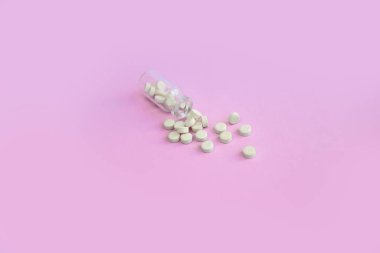 Pembe arka planda homeopatik globullar ve cam şişe. Alternatif Homeopati