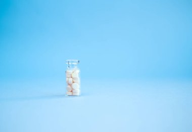 Pembe arka planda homeopatik globullar ve cam şişe. Alternatif Homeopati