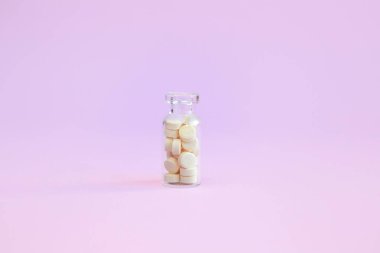 Pembe arka planda homeopatik globullar ve cam şişe. Alternatif Homeopati