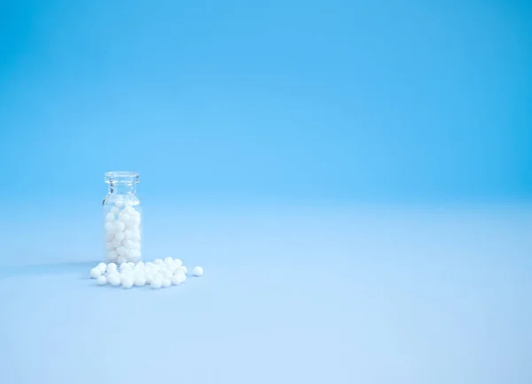 Homeopathische bolletjes en glazen fles op roze achtergrond. Alternatieve Homeopathie — Stockfoto