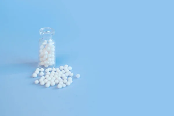 Glóbulos homeopáticos e garrafa de vidro sobre fundo rosa. Homeopatia alternativa — Fotografia de Stock