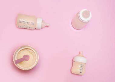 Pembe arka planda bir bebek için bir şişe süt..