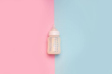 Pembe arka planda bir bebek için bir şişe süt..