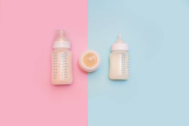 Pembe arka planda bir bebek için bir şişe süt..