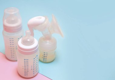 Pembe arka planda bir bebek için bir şişe süt..