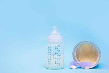 Pembe arka planda bir bebek için bir şişe süt..