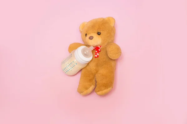 Garrafa de leite para um recém-nascido em um fundo rosa . — Fotografia de Stock