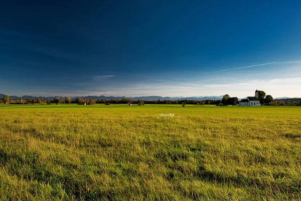 绿油油的草地 明亮的蓝天和一个小教堂 巴伐利亚田园诗 — 图库照片