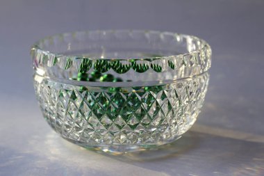 Çok güzel bir klasik el yapımı elmas kesimli cam kâse, parlak doğal ışığı yansıtıyor.