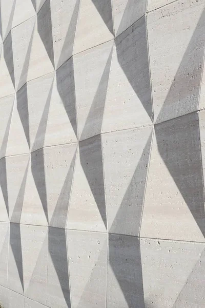 Diamond pattern stone wall texture background with three dimensional shape capturing late day sun shadows
