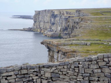 İrlanda 'nın Galway ilçesi Inis Mor adasındaki eski Dun Aengus kalesinin (Dun Aonghasa) dışındaki engebeli uçurumların manzarası.