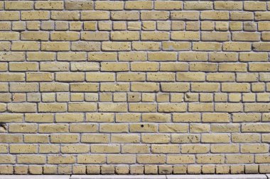 Kırsal antika bej kil tuğla duvar arka planında aşınmış bir görünüme sahip, ortak bir bağ tuğla kalıbında