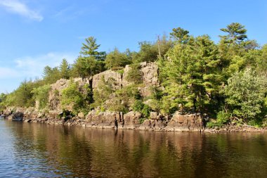 Buzul oymalı kireçtaşı kayalıkları olan güzel geniş bir nehrin manzarası.
