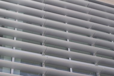 Yüksek bir binanın dış enerji tasarruflu pencerelerinin yukarı bakımı çekici modern tasarımına katkı sağlıyor.