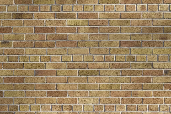 Vintage traditional brick wall texture background with bricks in varying shades of brown, tan, and salmon color, in a common bond brickwork pattern