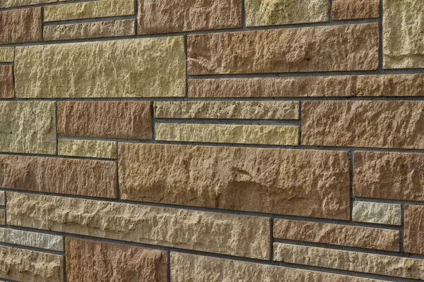 近景吸引人的现代石灰石砌体墙纹理背景砖的不同大小和色调的褐色和米黄色 角度视图 — 图库照片