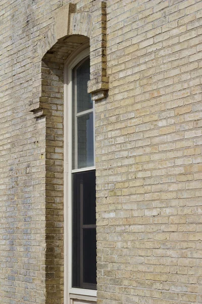背の高い窓と明るい日差しとヴィンテージベージュレンガの壁のテクスチャの背景の側面の角度ビュー — ストック写真