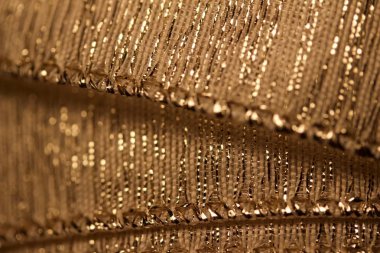 Bokeh ile güzel odaklanmış altın kumaş kurdele dokusunun makro arkaplanı