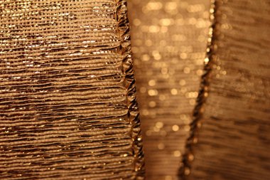 Bokeh ile güzel odaklanmış altın kumaş kurdele dokusunun makro arkaplanı