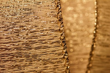Bokeh ile güzel odaklanmış altın kumaş kurdele dokusunun makro arkaplanı