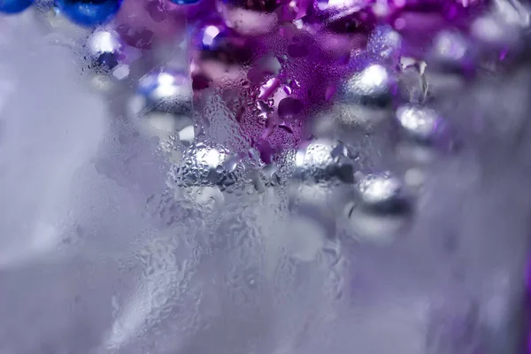 Yoğunlaştırılmış Renkli Metal Boncuklu Bir Bardakta Çözünmüş Buz Küplerinin Makro — Stok fotoğraf